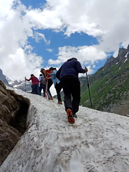 Hikers walking up a glacier in the mountains